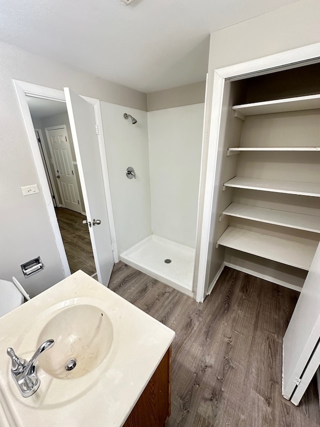 bathroom featuring a shower, hardwood / wood-style floors, and vanity