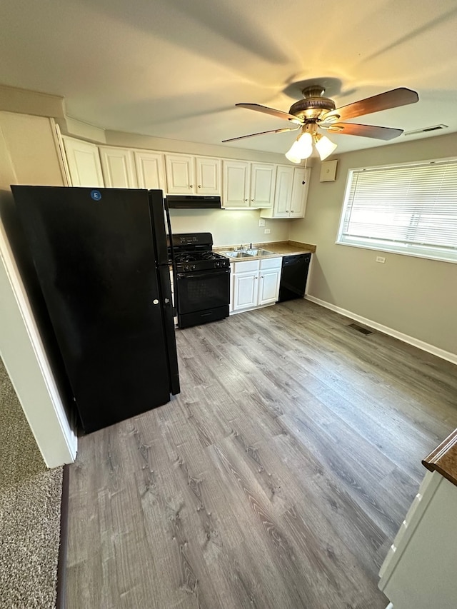 kitchen with light hardwood / wood-style flooring, ceiling fan, black appliances, white cabinets, and sink