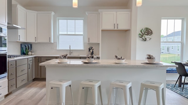 kitchen with hanging light fixtures, light stone counters, and white cabinets