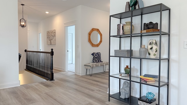 corridor with recessed lighting, an inviting chandelier, an upstairs landing, wood finished floors, and baseboards