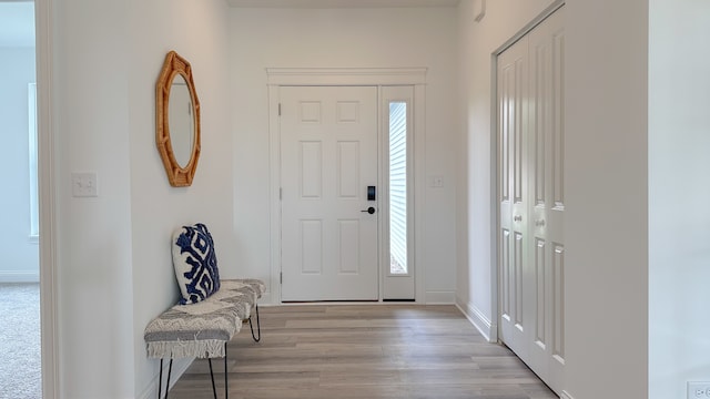 foyer entrance featuring light wood-type flooring and baseboards