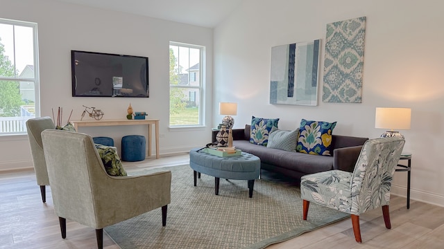 living room with vaulted ceiling, wood finished floors, and baseboards