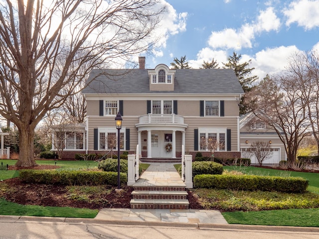 view of front of property featuring a balcony and a garage