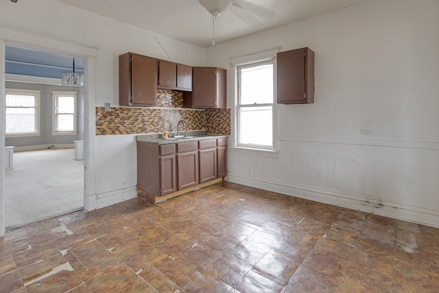 kitchen featuring tasteful backsplash, tile floors, ceiling fan, and sink