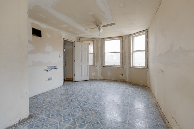 empty room with ceiling fan and tile floors