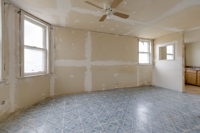 tiled spare room featuring ceiling fan