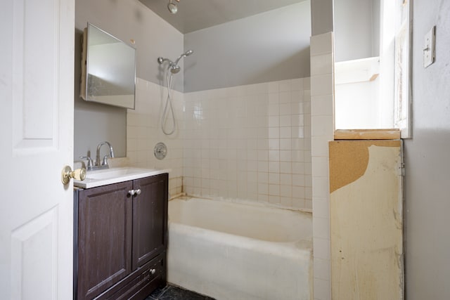 bathroom featuring vanity and tiled shower / bath