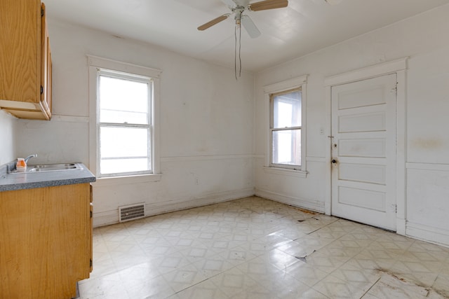 kitchen with sink, ceiling fan, and light tile flooring