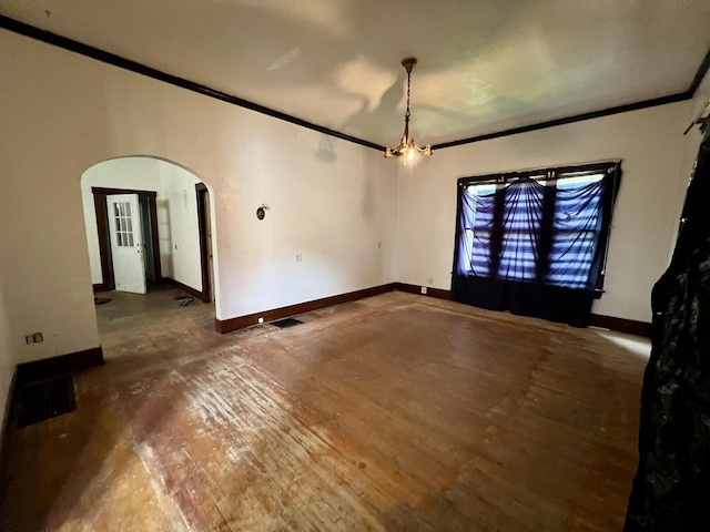 657 W Wood St, Decatur, IL 62522 - empty room featuring arched walkways, crown molding, baseboards, and wood finished floors