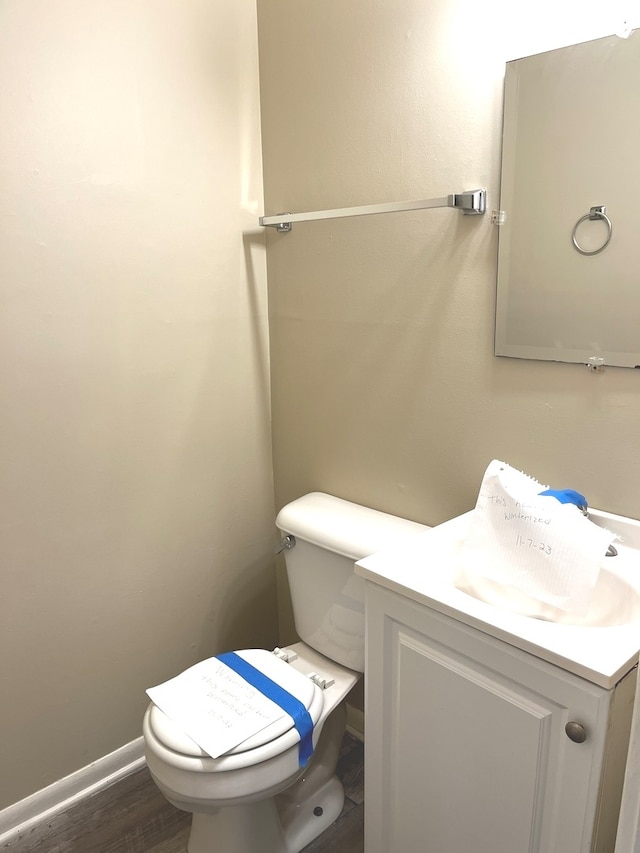 bathroom featuring vanity, toilet, and hardwood / wood-style flooring