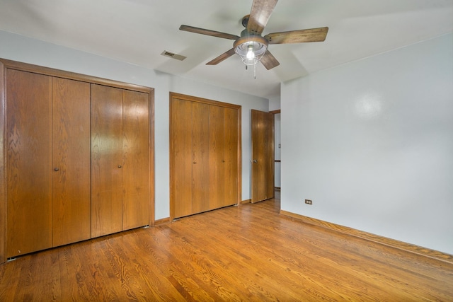 6840 157th St, Tinley Park, IL 60477 - unfurnished bedroom featuring two closets, wood finished floors, ceiling fan, and baseboards