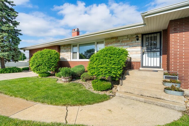 6840 157th St, Tinley Park, IL 60477 - property entrance featuring a chimney, stone siding, brick siding, and a yard