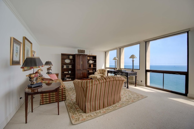 living area with light colored carpet, a water view, baseboards, ornamental molding, and a wall of windows