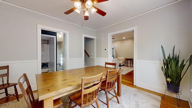 dining area with hardwood / wood-style flooring, ornamental molding, and ceiling fan