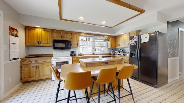 kitchen with a kitchen island, a breakfast bar, and black appliances