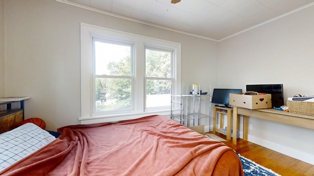 bedroom featuring wood-type flooring and crown molding