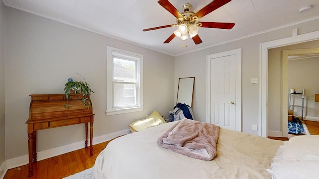 bedroom featuring ornamental molding, ceiling fan, and hardwood / wood-style flooring