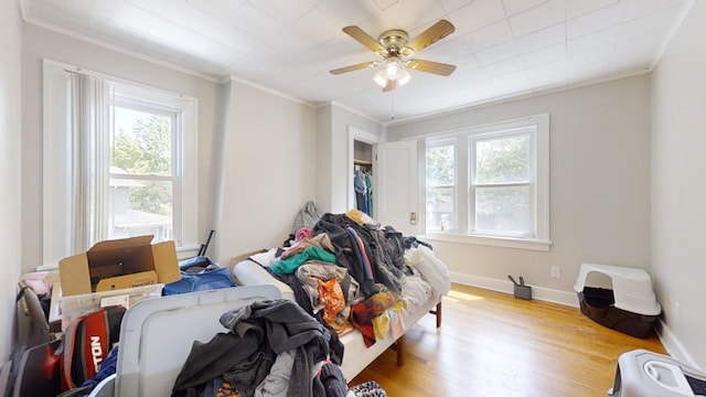 bedroom featuring ceiling fan, crown molding, and hardwood / wood-style flooring