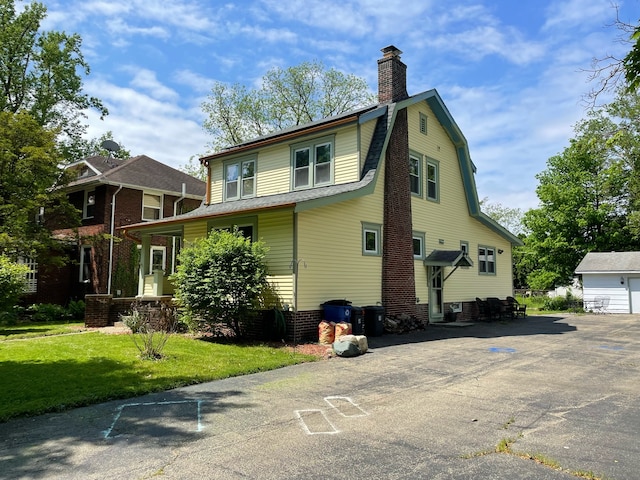 view of front of home with an outdoor structure, a garage, and a front yard