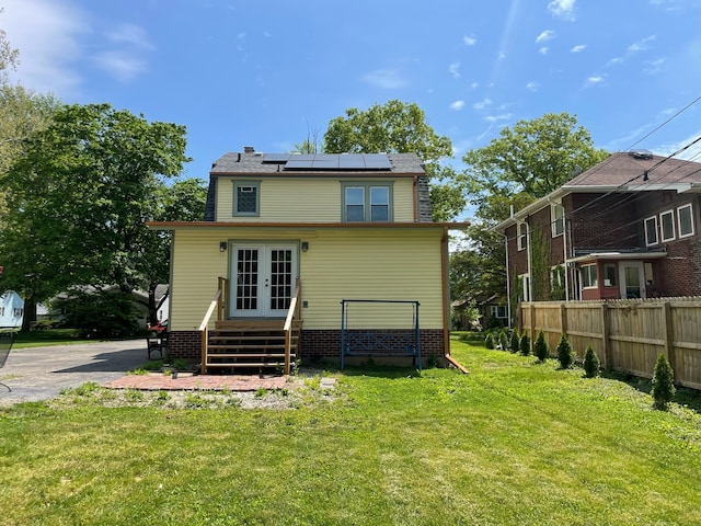 back of house featuring solar panels and a yard