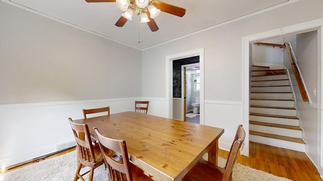 dining area with ceiling fan, crown molding, and hardwood / wood-style flooring