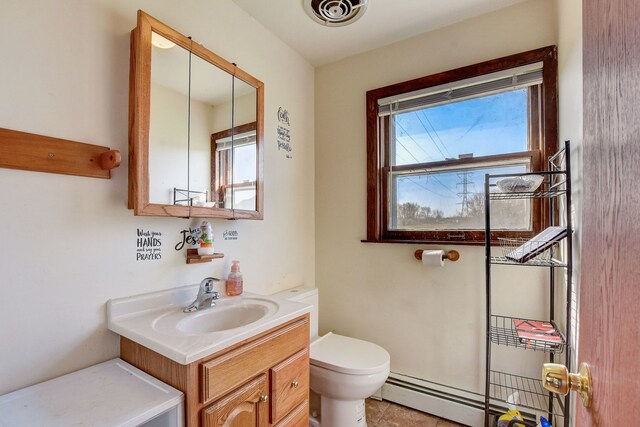 bathroom featuring tile patterned flooring, toilet, baseboard heating, and vanity