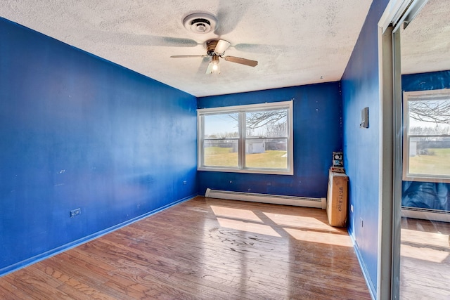 unfurnished room featuring light hardwood / wood-style flooring, ceiling fan, and baseboard heating