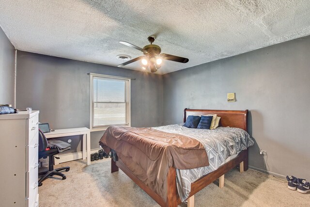 carpeted bedroom featuring a textured ceiling and ceiling fan