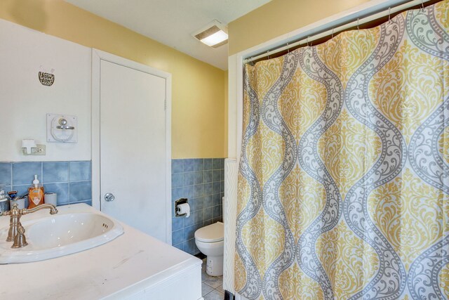 bathroom with sink, tile walls, toilet, and tile patterned floors