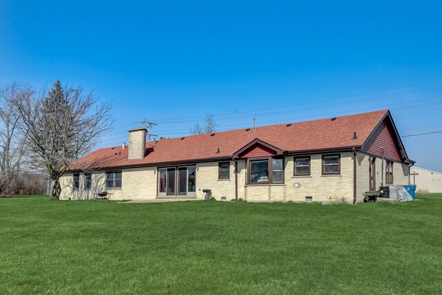 back of property with a lawn and cooling unit