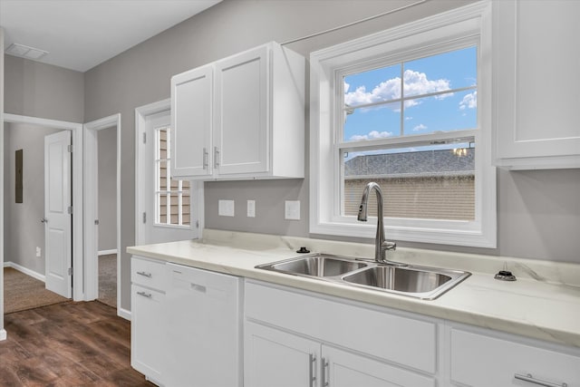 kitchen with light stone countertops, dishwasher, sink, dark wood-type flooring, and white cabinets