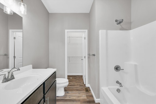 full bathroom featuring hardwood / wood-style floors, vanity, shower / bathtub combination, and toilet