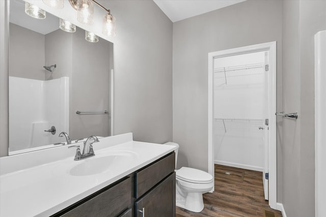 bathroom featuring vanity, wood-type flooring, and toilet