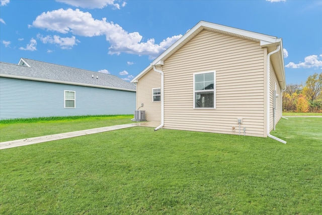 back of property with a yard and central AC unit