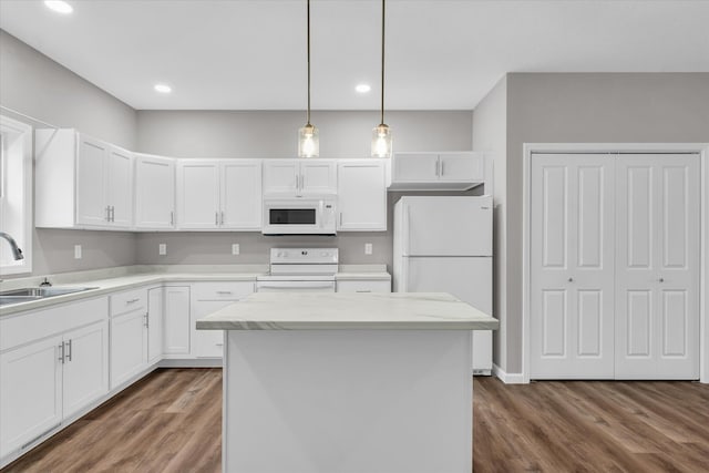 kitchen with sink, dark wood-type flooring, a kitchen island, white appliances, and white cabinets