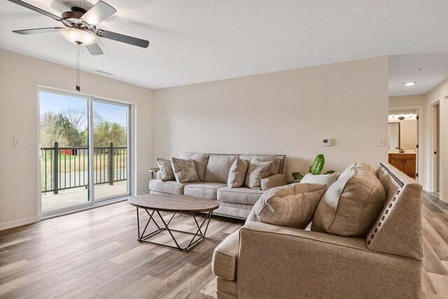 living room with ceiling fan and light hardwood / wood-style floors