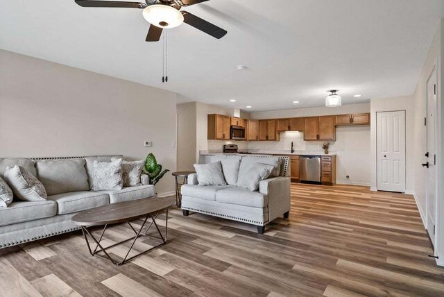 living room featuring ceiling fan and hardwood / wood-style flooring