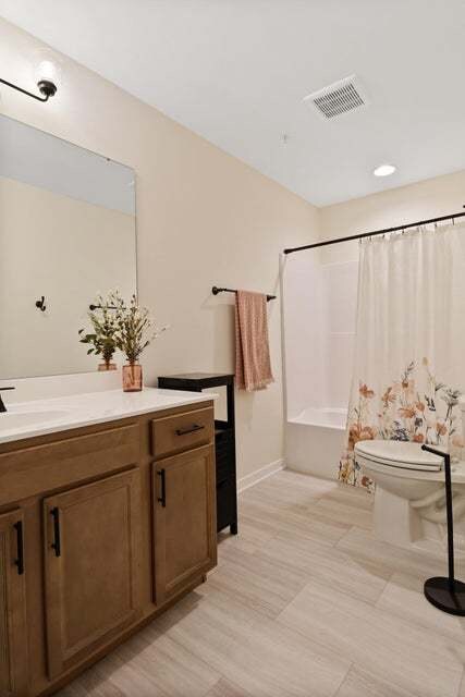 full bathroom with shower / tub combo, toilet, and vanity