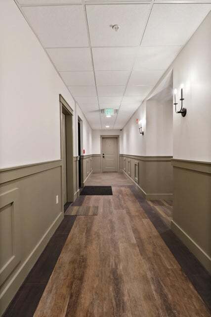 hallway with dark hardwood / wood-style flooring and a paneled ceiling