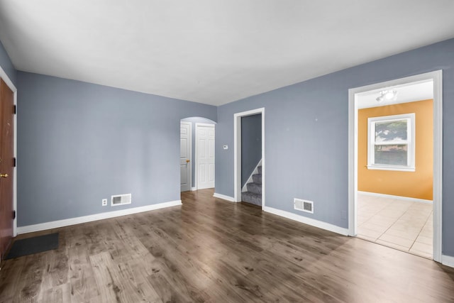 12233 S Morgan St, Chicago, IL 60643 - empty room featuring arched walkways, stairs, wood finished floors, and baseboards