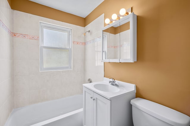 full bathroom featuring vanity, tiled shower / bath combo, and toilet