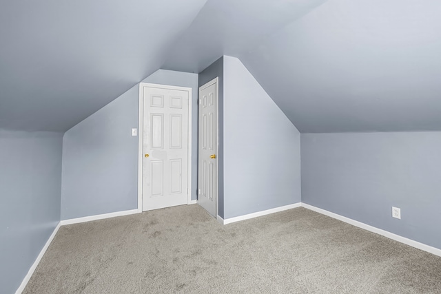 additional living space featuring carpet floors and vaulted ceiling