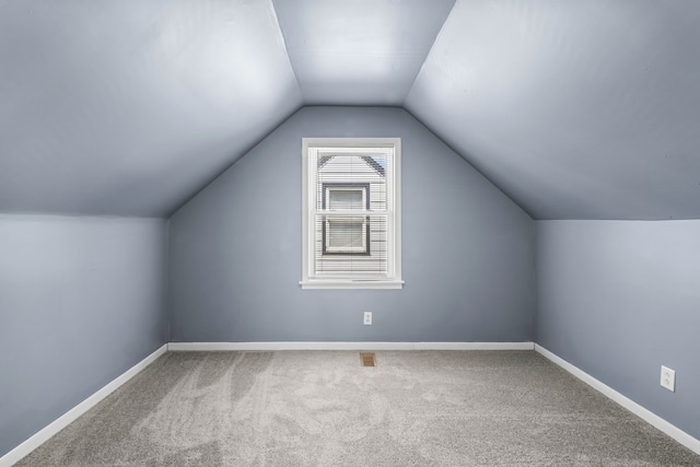 bonus room featuring vaulted ceiling and carpet flooring