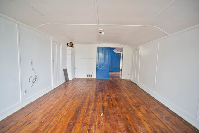 spare room featuring lofted ceiling and dark wood-type flooring