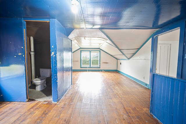 additional living space with vaulted ceiling and hardwood / wood-style floors