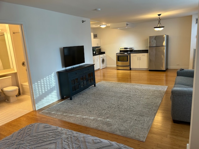 living room featuring light wood-type flooring and washer / clothes dryer