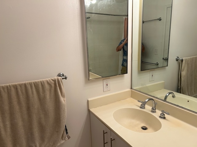 bathroom featuring walk in shower and vanity