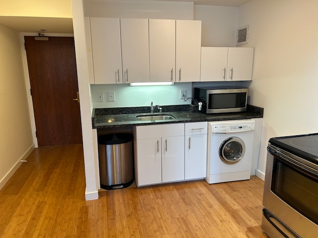 kitchen featuring electric range, washer / clothes dryer, sink, and white cabinetry