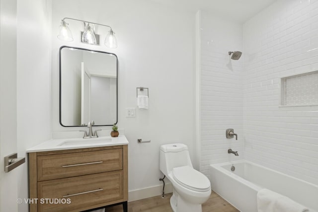 full bathroom featuring tiled shower / bath, hardwood / wood-style floors, vanity, and toilet