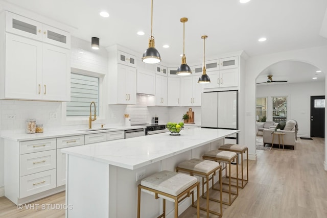 kitchen featuring sink, white cabinetry, a center island, electric range oven, and white fridge